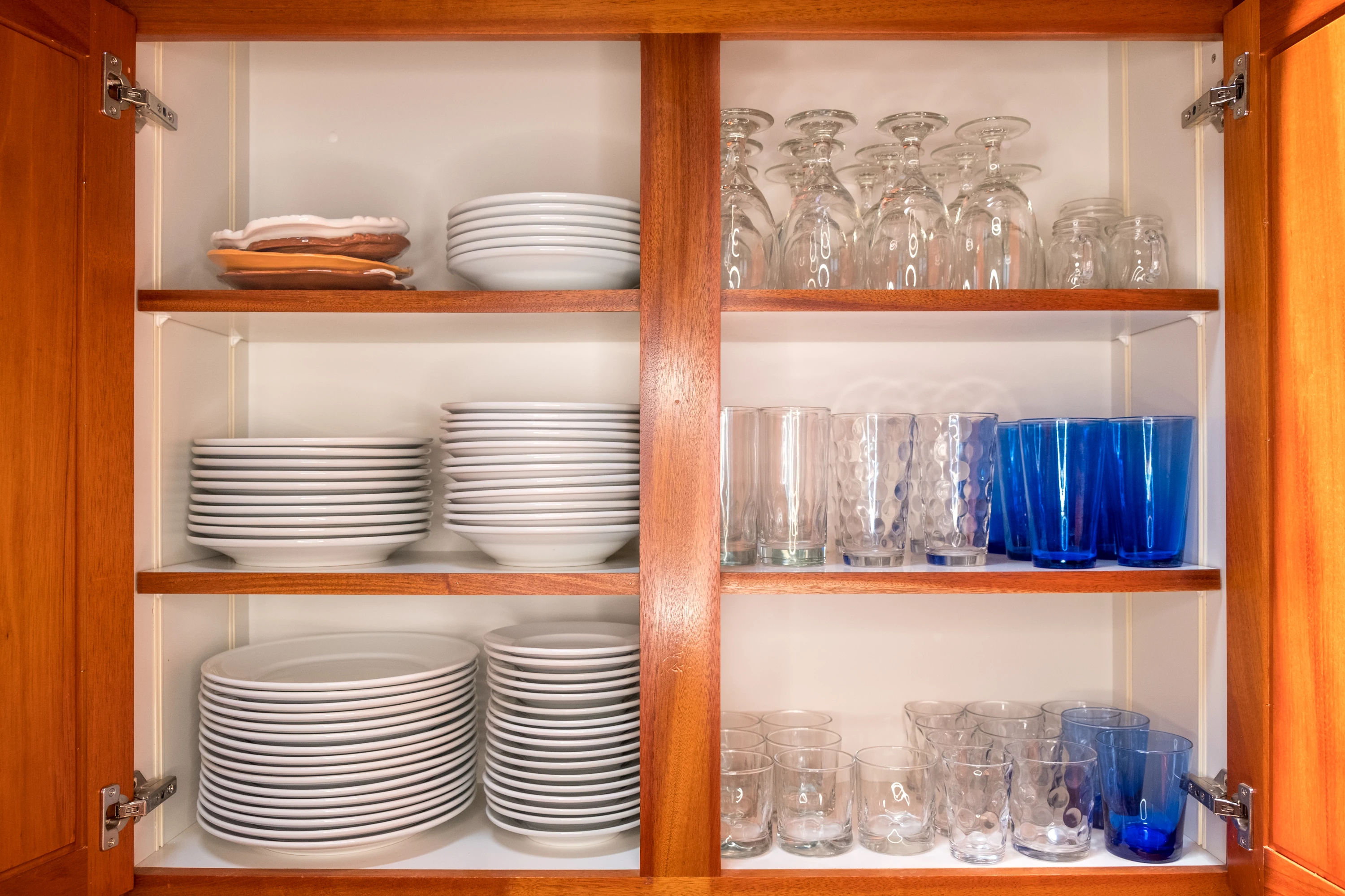 Organized plates and bowls in a double cabinet